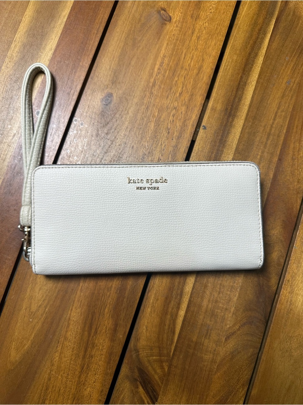 kate spade cream leather wristlet wallet with gold logo and pink interior